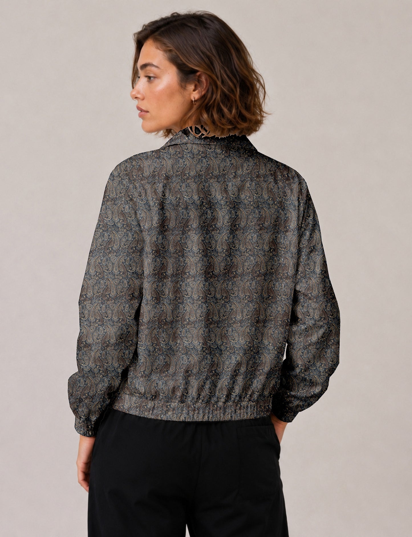 Brown floral bomber jacket with front zipper, elastic cuffs and hem, hanging on white hanger, red floral inner lining visible
