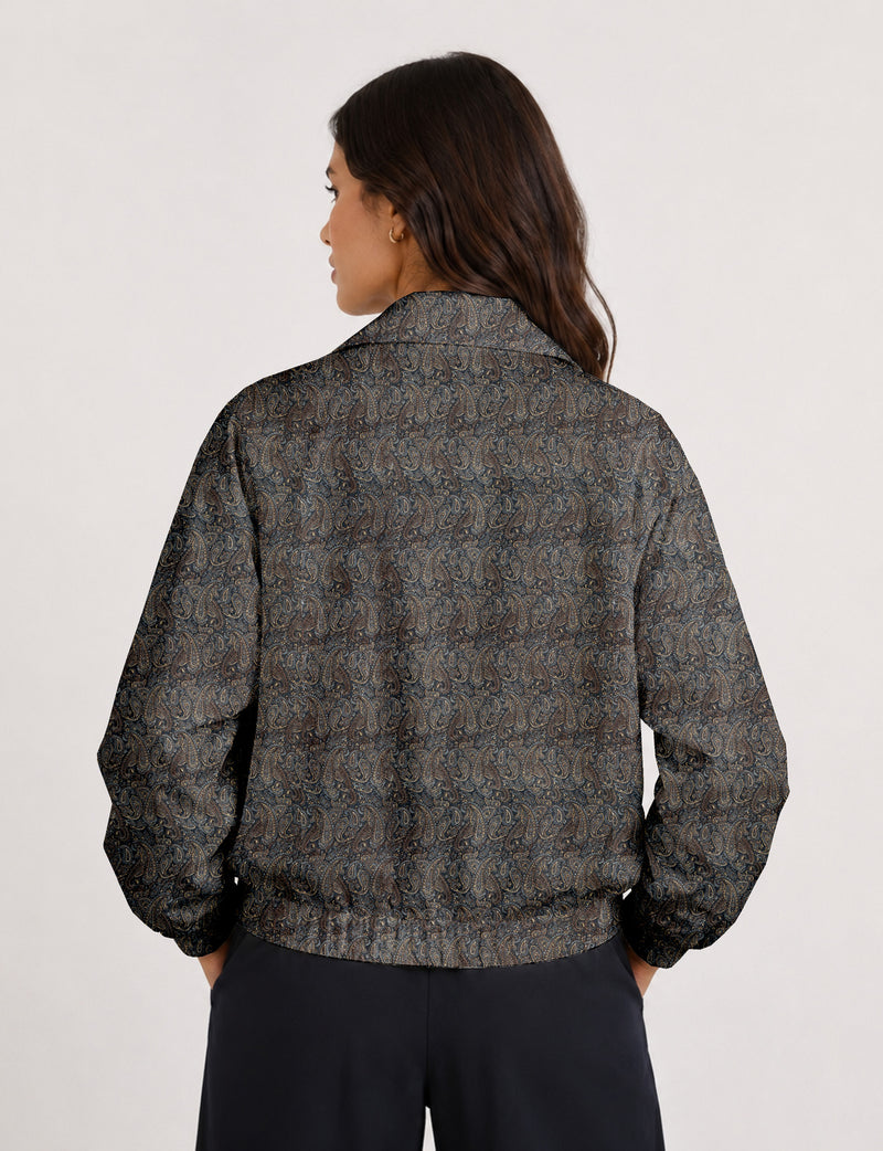 Woman wearing a yellow floral bomber jacket with front zipper, elastic cuffs, and side pockets, shown from front view