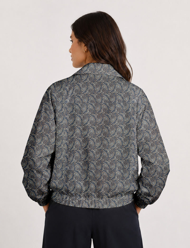 Woman wearing a yellow floral bomber jacket with front zipper, elastic cuffs, and side pockets, shown from front view