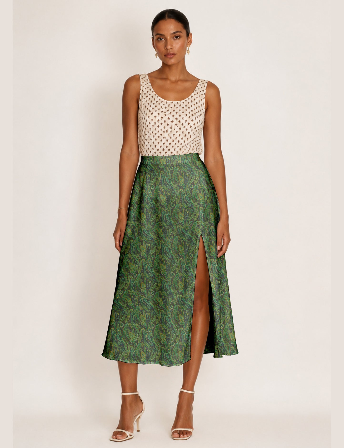 Woman wearing a yellow and black micro patterned A-line skirt with front slit, paired with beige sleeveless top and black