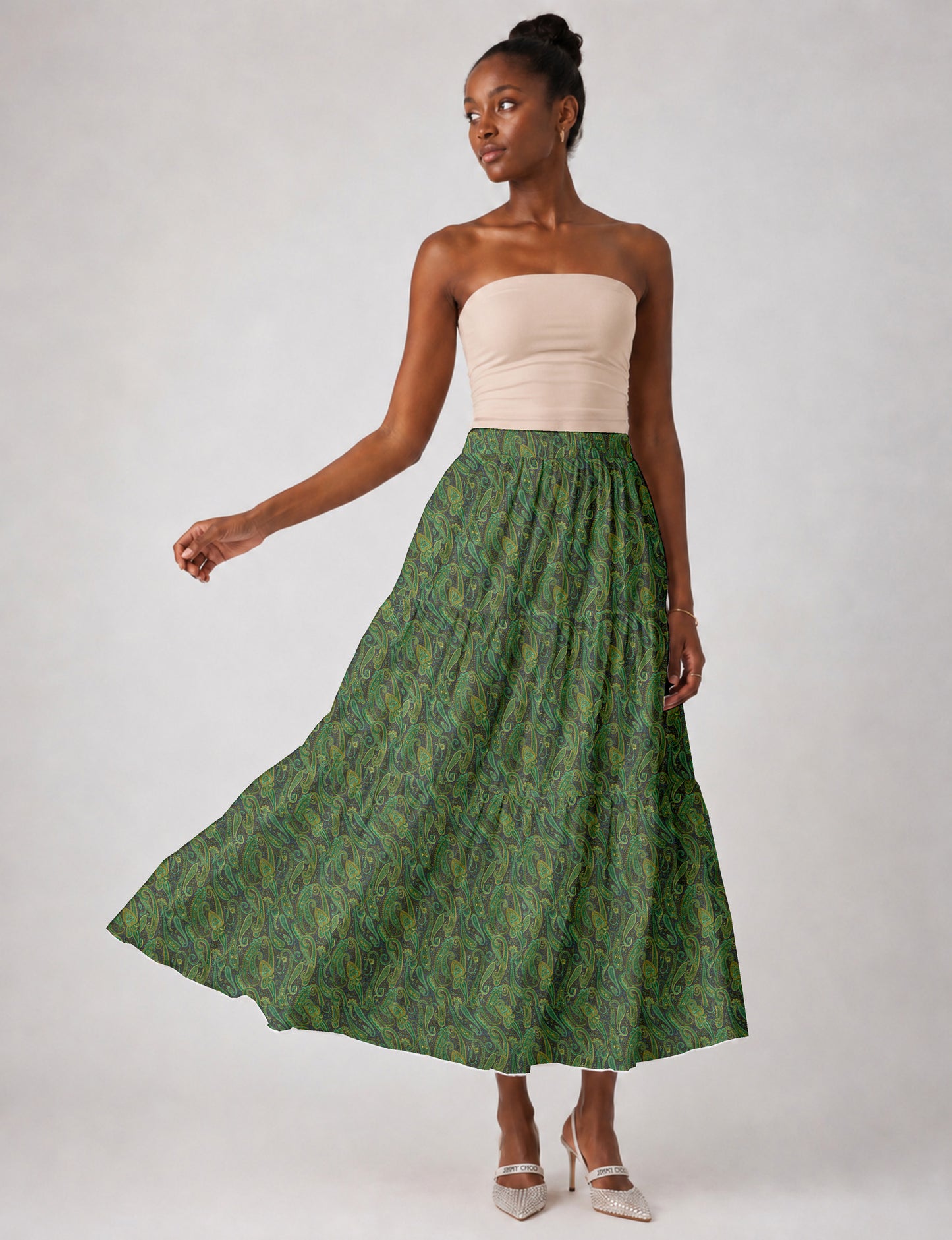 Woman wearing a yellow midi tiered skirt with a small geometric pattern, shown from the back, paired with beige top and