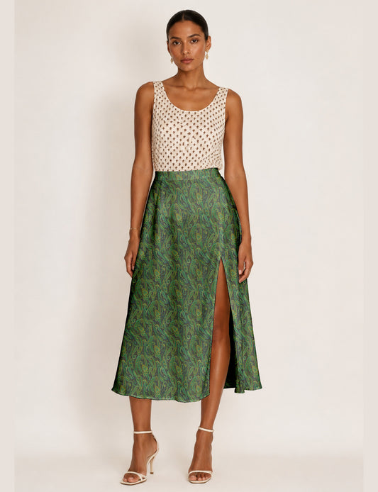 Woman wearing a yellow and black micro patterned A-line skirt with front slit, paired with beige sleeveless top and black