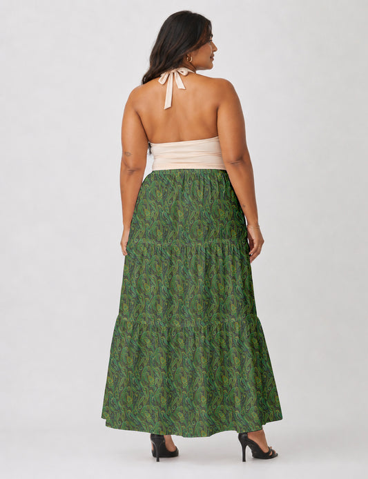 Woman wearing a yellow midi tiered skirt with a small geometric pattern, paired with a beige strapless top and white heels