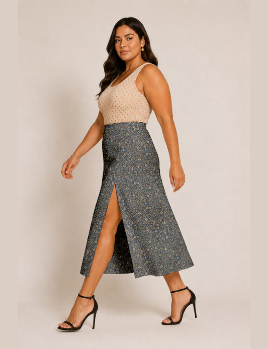Woman wearing a yellow and black micro patterned A-line skirt with front slit, paired with beige sleeveless top and black