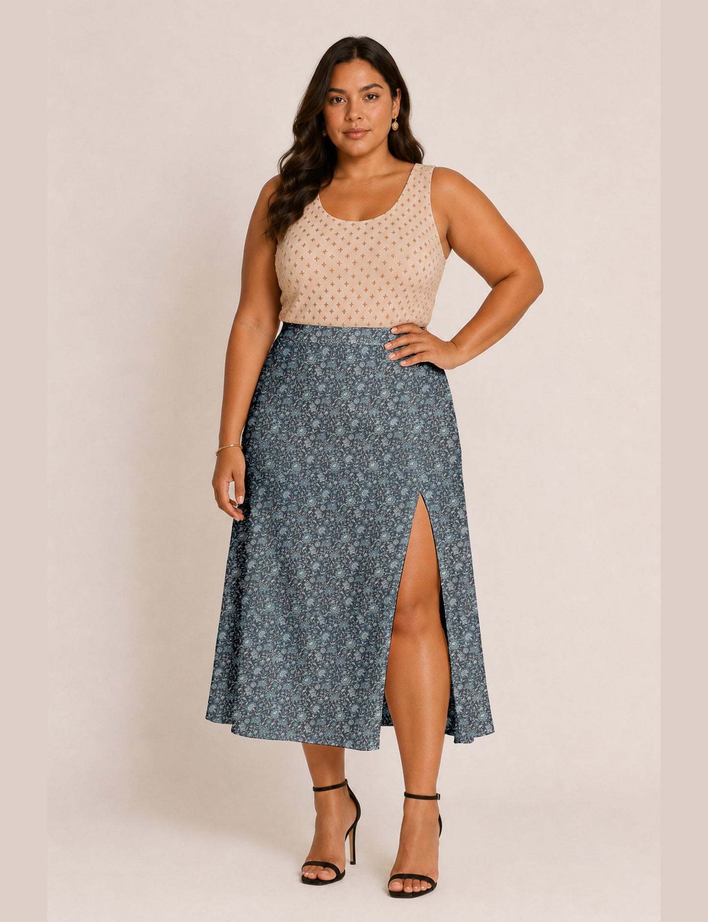 Woman wearing a yellow and black micro patterned A-line skirt with front slit, paired with beige sleeveless top and black