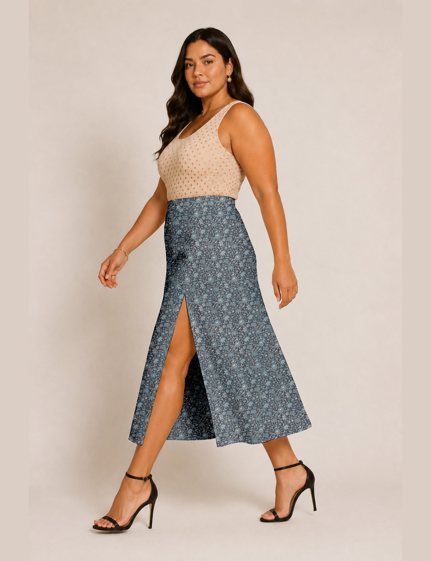 Woman wearing a yellow and black micro patterned A-line skirt with front slit, paired with beige sleeveless top and black