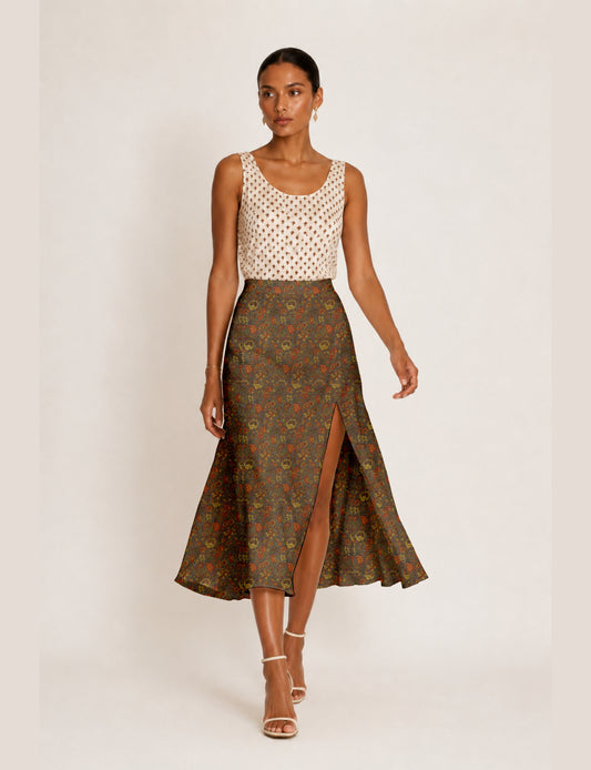 Woman wearing a yellow and black micro patterned A-line skirt with front slit, paired with beige sleeveless top and black