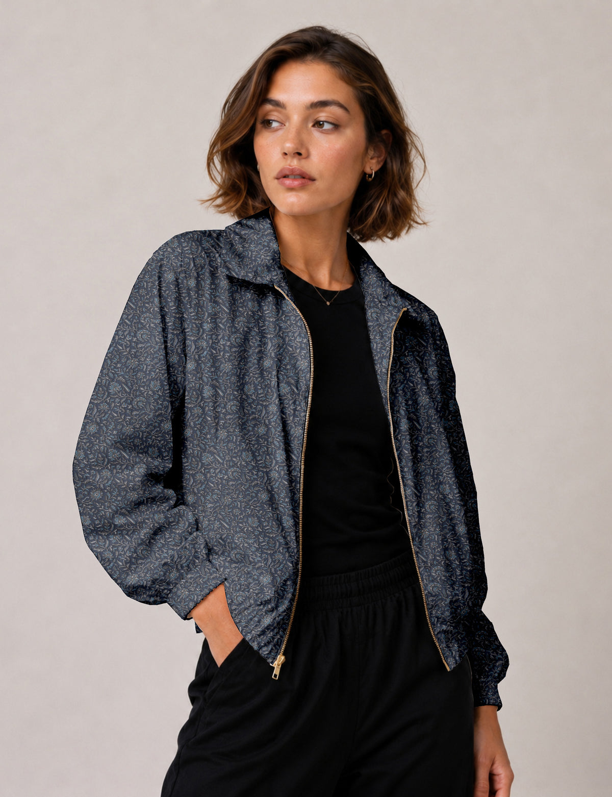 Brown floral bomber jacket with front zipper, elastic cuffs and hem, hanging on white hanger, red floral inner lining visible