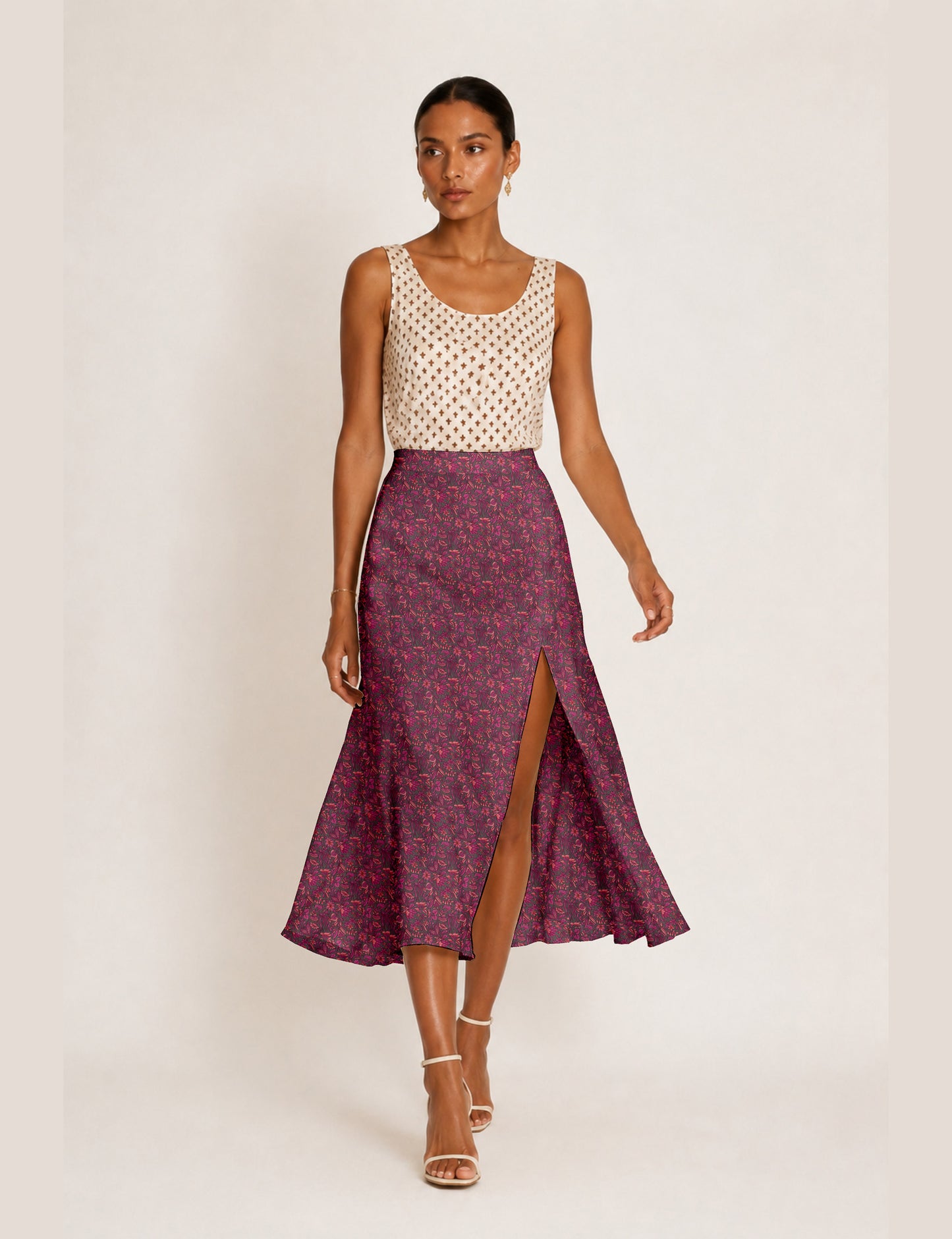 Woman wearing a yellow and black micro patterned A-line skirt with front slit, paired with beige sleeveless top and black