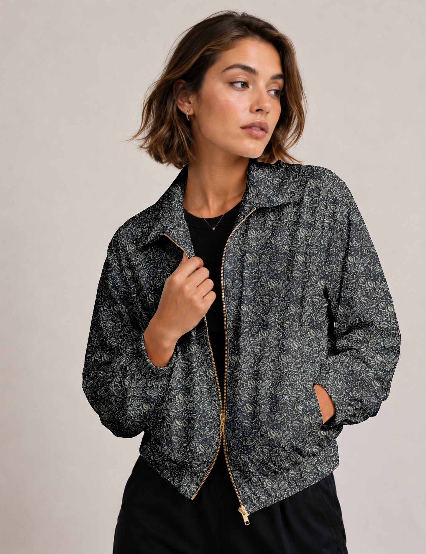 Brown floral bomber jacket with front zipper, elastic cuffs and hem, hanging on white hanger, red floral inner lining visible