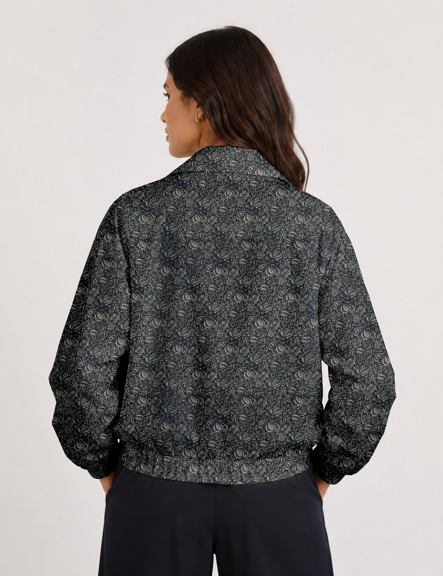 Woman wearing a yellow floral bomber jacket with front zipper, elastic cuffs, and side pockets, shown from front view