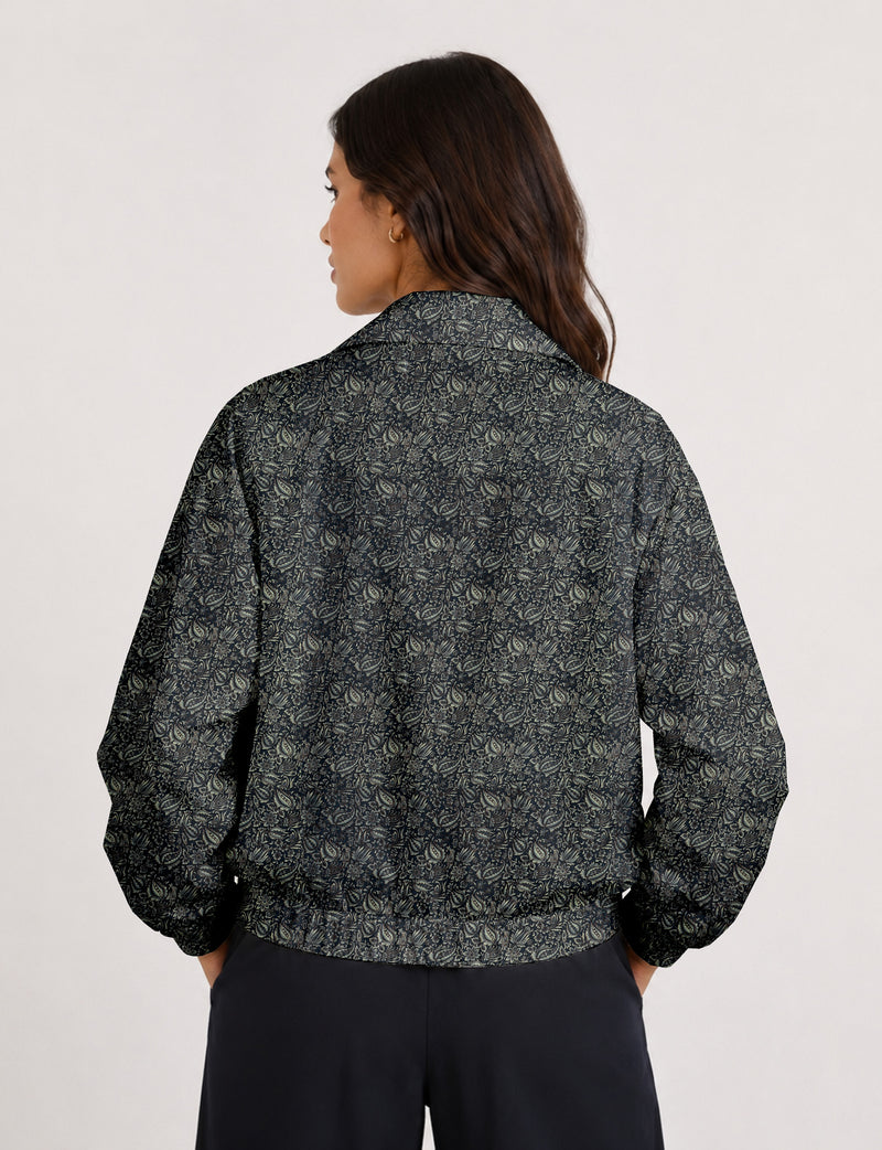 Woman wearing a yellow floral bomber jacket with front zipper, elastic cuffs, and side pockets, shown from front view