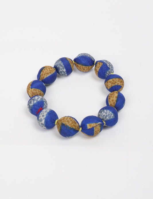 Eco friendly beaded knotted bracelet crafted from upcycled women’s clothing and repurposed sari fabrics, showcasing circular fashion and sustainable apparel.