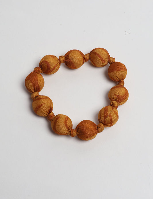 Eco friendly beaded knotted bracelet crafted from upcycled women’s clothing and repurposed sari fabrics, showcasing circular fashion and sustainable apparel.