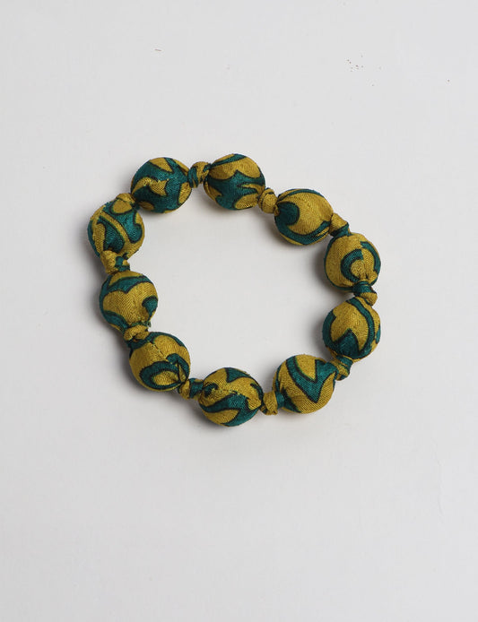 Eco friendly beaded knotted bracelet crafted from upcycled women’s clothing and repurposed sari fabrics, showcasing circular fashion and sustainable apparel.