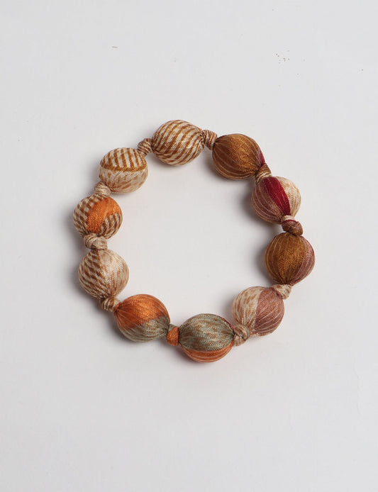 Eco friendly beaded knotted bracelet crafted from upcycled women’s clothing and repurposed sari fabrics, showcasing circular fashion and sustainable apparel.