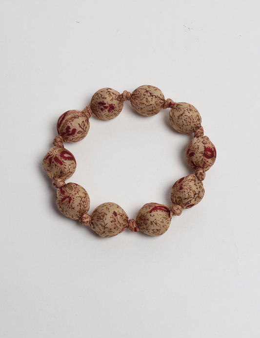 Eco friendly beaded knotted bracelet crafted from upcycled women’s clothing and repurposed sari fabrics, showcasing circular fashion and sustainable apparel.