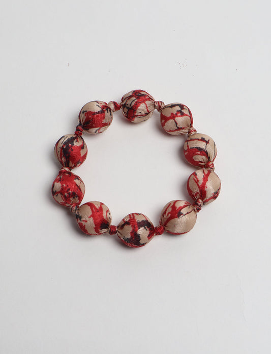 Eco friendly beaded knotted bracelet crafted from upcycled women’s clothing and repurposed sari fabrics, showcasing circular fashion and sustainable apparel.