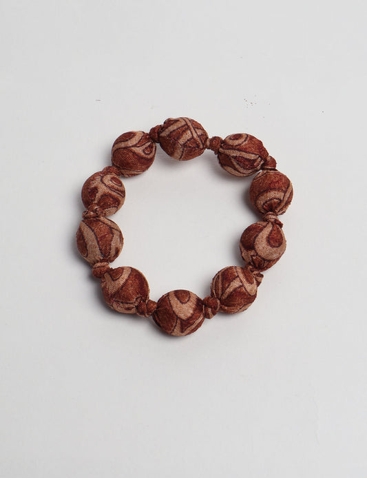 Eco friendly beaded knotted bracelet crafted from upcycled women’s clothing and repurposed sari fabrics, showcasing circular fashion and sustainable apparel.