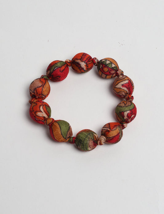 Eco friendly beaded knotted bracelet crafted from upcycled women’s clothing and repurposed sari fabrics, showcasing circular fashion and sustainable apparel.