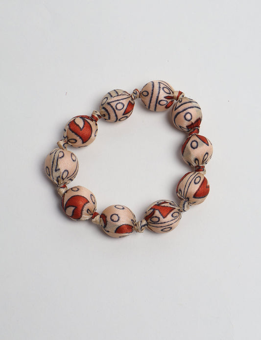 Eco friendly beaded knotted bracelet crafted from upcycled women’s clothing and repurposed sari fabrics, showcasing circular fashion and sustainable apparel.