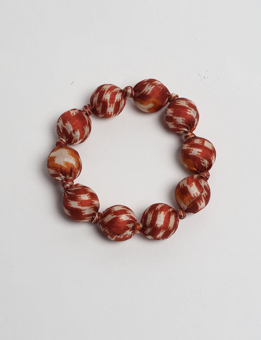 Eco friendly beaded knotted bracelet crafted from upcycled women’s clothing and repurposed sari fabrics, showcasing circular fashion and sustainable apparel.