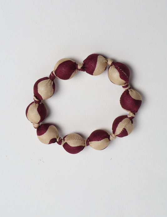 Eco friendly beaded knotted bracelet crafted from upcycled women’s clothing and repurposed sari fabrics, showcasing circular fashion and sustainable apparel.
