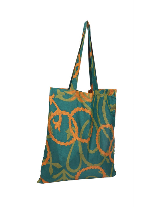 Colorful shopper bag made from recycled sari fabric, representing eco clothing, sustainable women's clothing, carbon neutral fashion, and repurposed clothing — ideal for environmentally friendly lifestyles and conscious clothing choices.