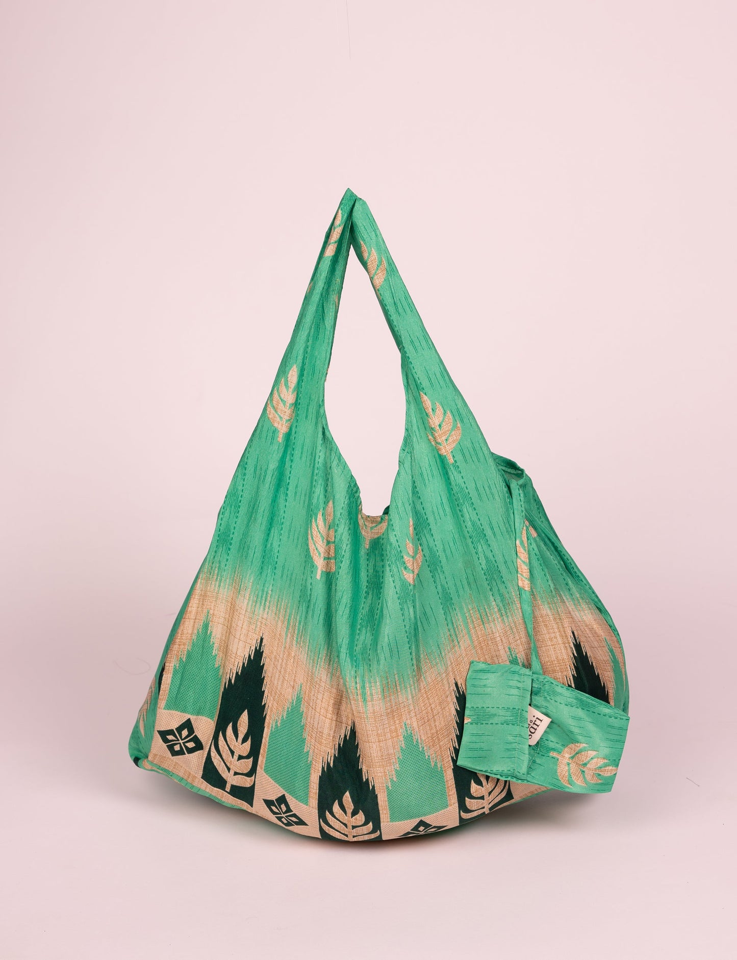 Stay eco-conscious with our Reusable Bag, handmade by Indian artisans from pre-loved saris. Silky and lightweight, this foldaway bag is perfect for your on-the-go lifestyle. Each piece is a unique statement of ethical fashion, embracing sustainability and style.