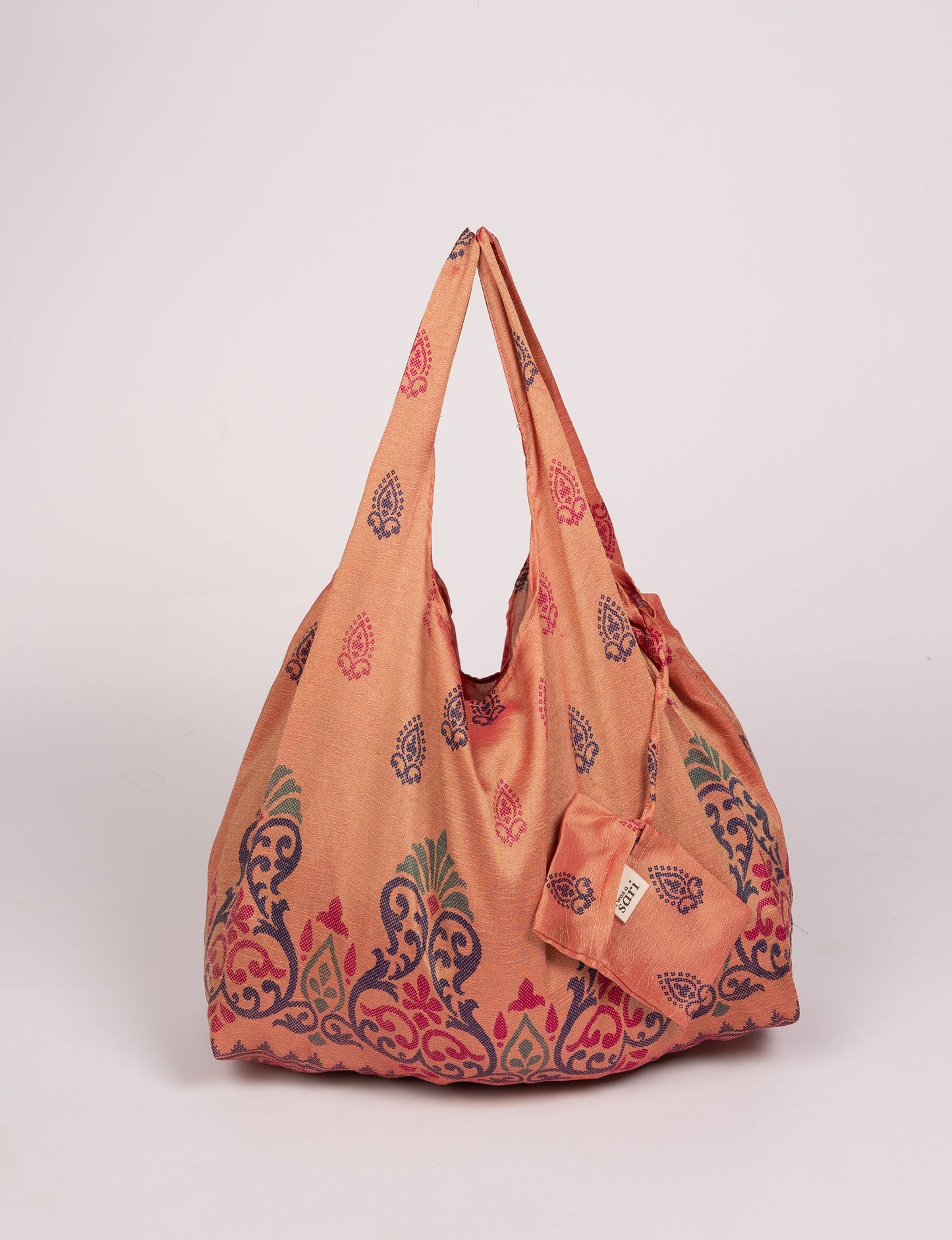 Stay eco-conscious with our Reusable Bag, handmade by Indian artisans from pre-loved saris. Silky and lightweight, this foldaway bag is perfect for your on-the-go lifestyle. Each piece is a unique statement of ethical fashion, embracing sustainability and style.