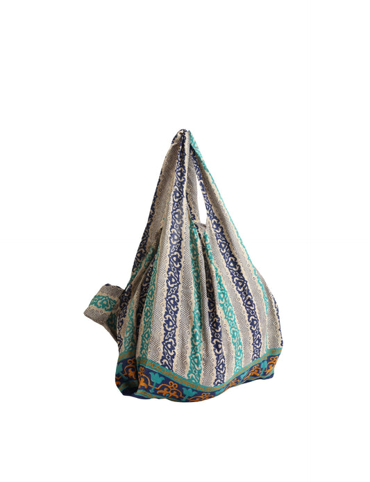 Stay eco-conscious with our Reusable Bag, handmade by Indian artisans from pre-loved saris. Silky and lightweight, this foldaway bag is perfect for your on-the-go lifestyle. Each piece is a unique statement of ethical fashion, embracing sustainability and style.