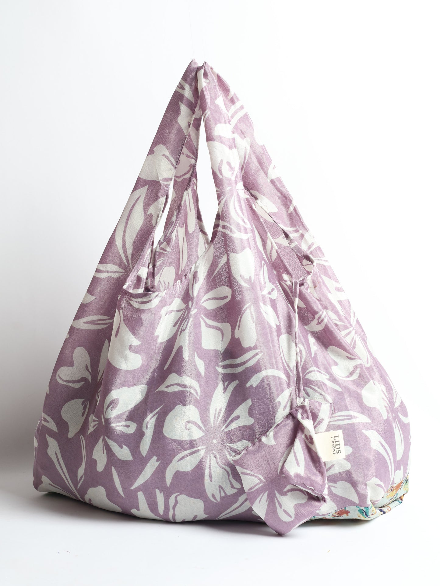 Stay eco-conscious with our Reusable Bag, handmade by Indian artisans from pre-loved saris. Silky and lightweight, this foldaway bag is perfect for your on-the-go lifestyle. Each piece is a unique statement of ethical fashion, embracing sustainability and style.