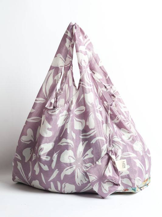 Stay eco-conscious with our Reusable Bag, handmade by Indian artisans from pre-loved saris. Silky and lightweight, this foldaway bag is perfect for your on-the-go lifestyle. Each piece is a unique statement of ethical fashion, embracing sustainability and style.