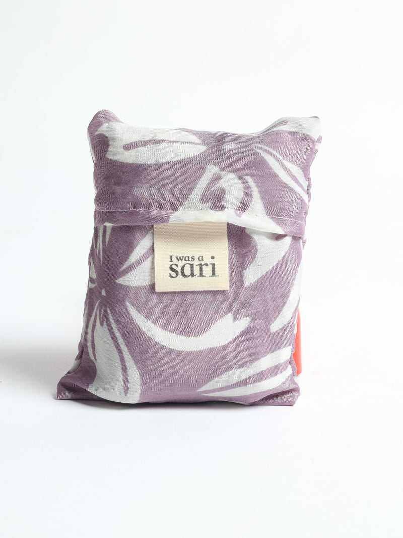 Stay eco-conscious with our Reusable Bag, handmade by Indian artisans from pre-loved saris. Silky and lightweight, this foldaway bag is perfect for your on-the-go lifestyle. Each piece is a unique statement of ethical fashion, embracing sustainability and style.