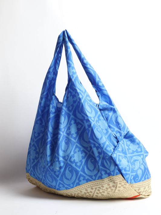 Stay eco-conscious with our Reusable Bag, handmade by Indian artisans from pre-loved saris. Silky and lightweight, this foldaway bag is perfect for your on-the-go lifestyle. Each piece is a unique statement of ethical fashion, embracing sustainability and style.