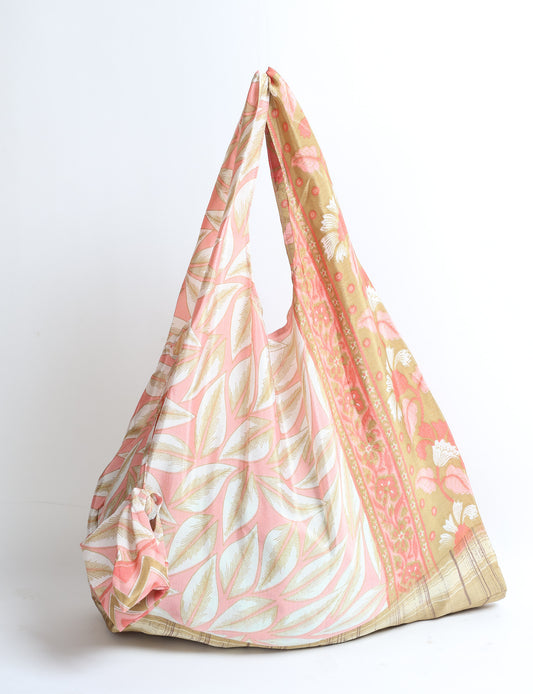 Stay eco-conscious with our Reusable Bag, handmade by Indian artisans from pre-loved saris. Silky and lightweight, this foldaway bag is perfect for your on-the-go lifestyle. Each piece is a unique statement of ethical fashion, embracing sustainability and style.