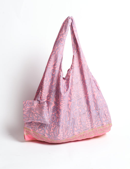 Stay eco-conscious with our Reusable Bag, handmade by Indian artisans from pre-loved saris. Silky and lightweight, this foldaway bag is perfect for your on-the-go lifestyle. Each piece is a unique statement of ethical fashion, embracing sustainability and style.