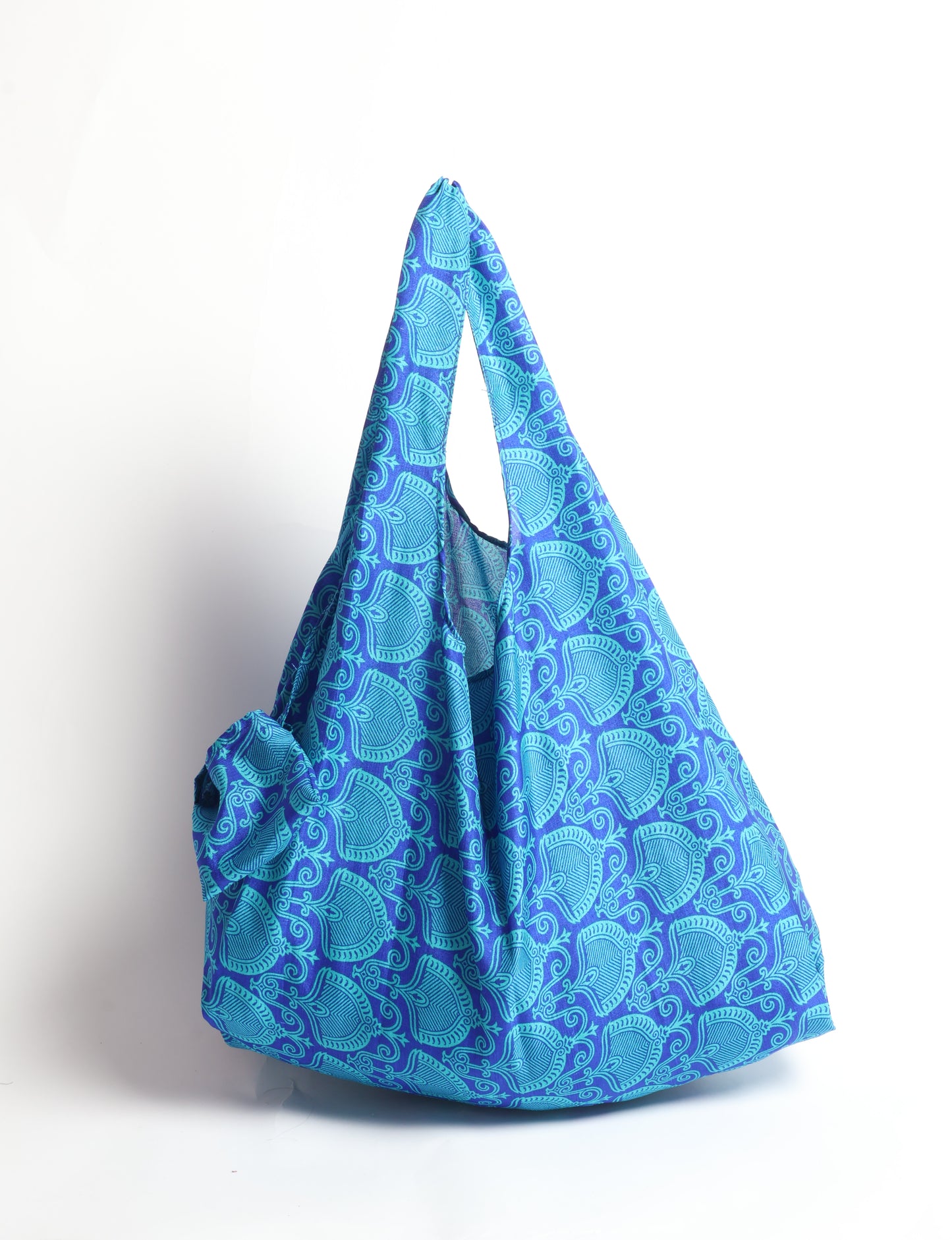 Stay eco-conscious with our Reusable Bag, handmade by Indian artisans from pre-loved saris. Silky and lightweight, this foldaway bag is perfect for your on-the-go lifestyle. Each piece is a unique statement of ethical fashion, embracing sustainability and style.