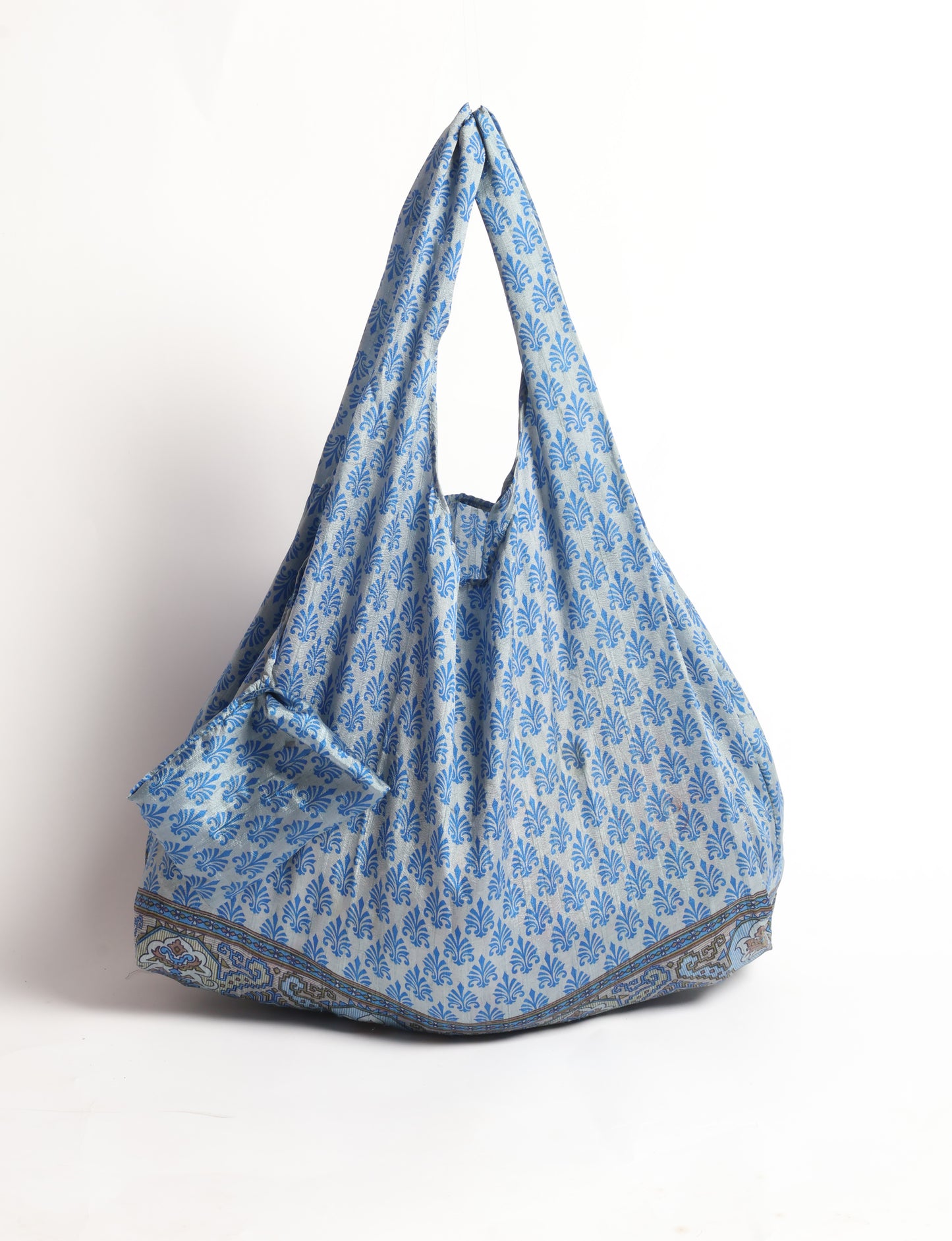 Stay eco-conscious with our Reusable Bag, handmade by Indian artisans from pre-loved saris. Silky and lightweight, this foldaway bag is perfect for your on-the-go lifestyle. Each piece is a unique statement of ethical fashion, embracing sustainability and style.