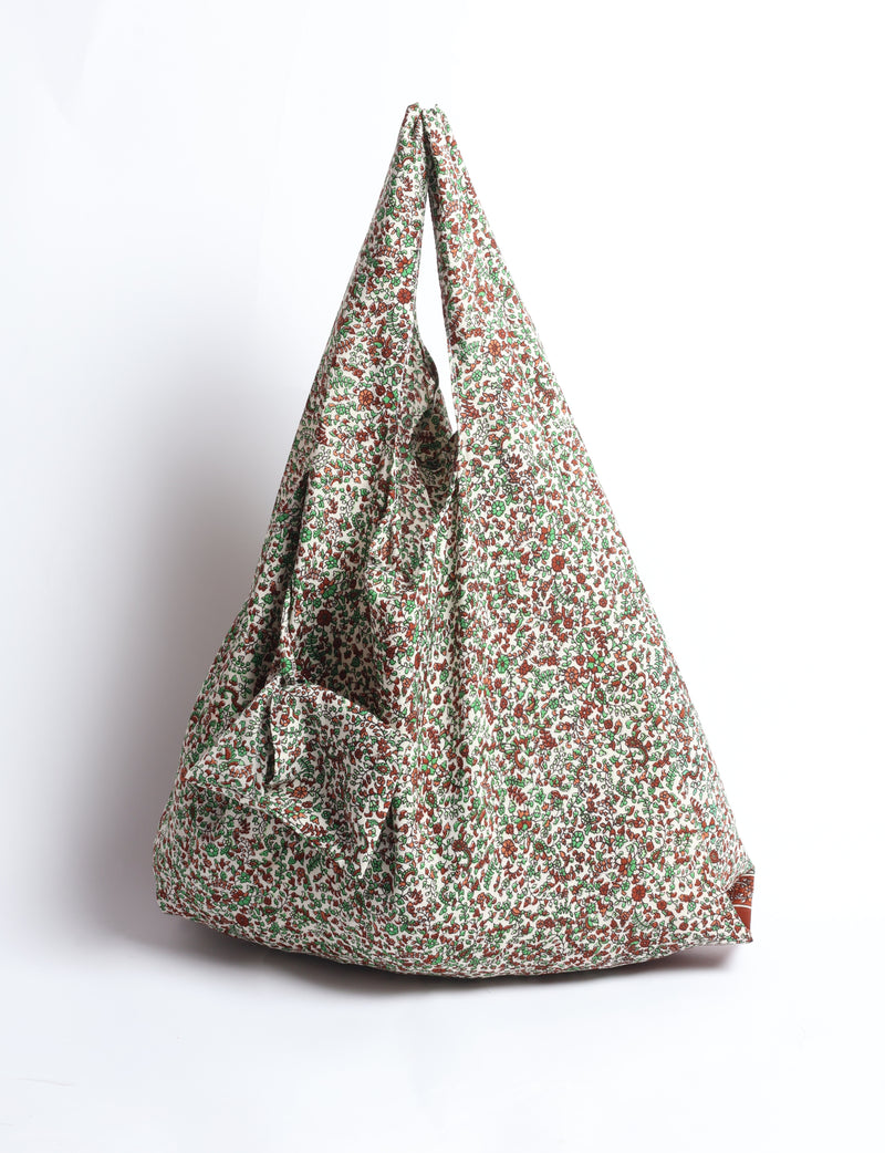 Beige reusable bag with small red and green floral pattern, hanging with handles together, front view