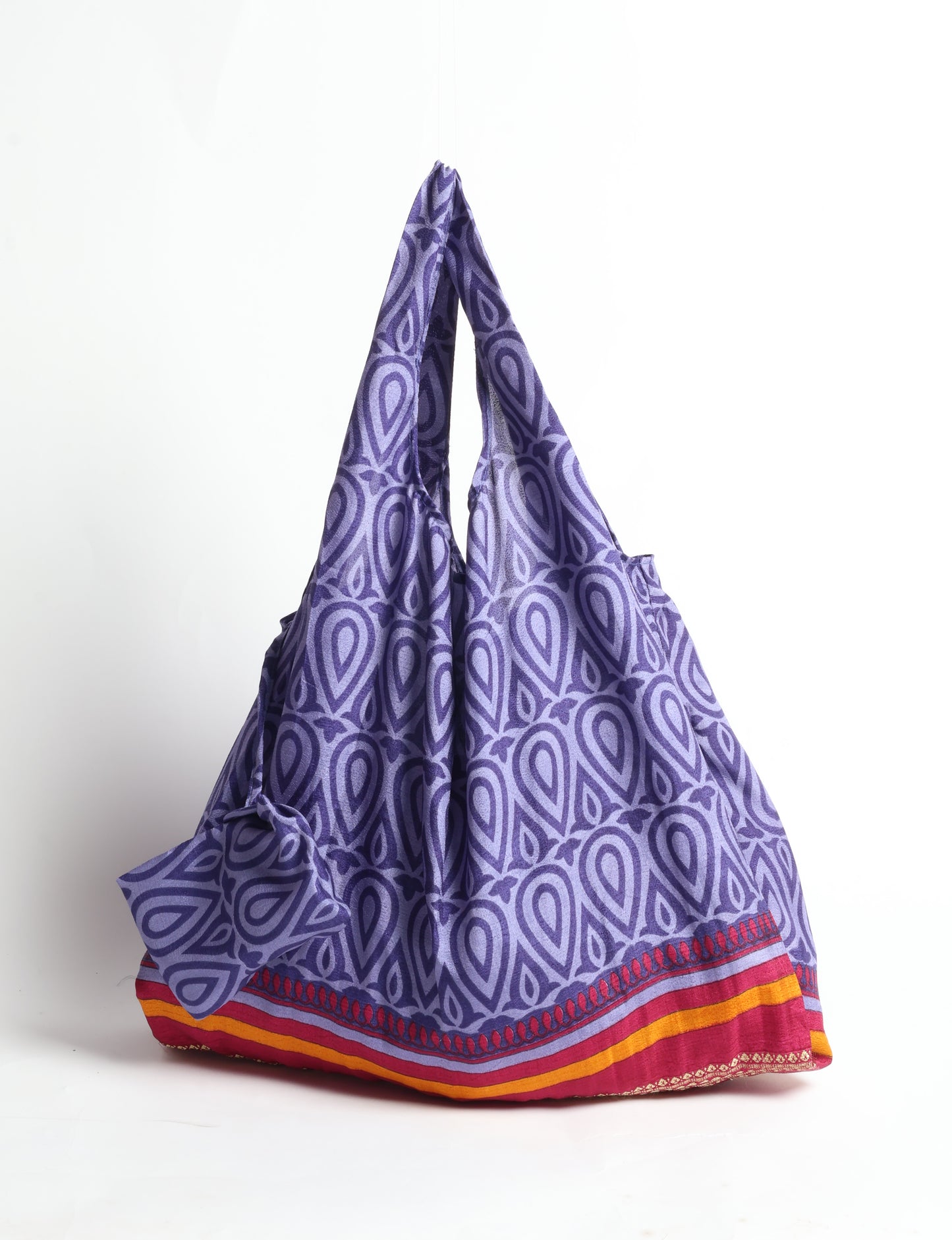 Stay eco-conscious with our Reusable Bag, handmade by Indian artisans from pre-loved saris. Silky and lightweight, this foldaway bag is perfect for your on-the-go lifestyle. Each piece is a unique statement of ethical fashion, embracing sustainability and style.
