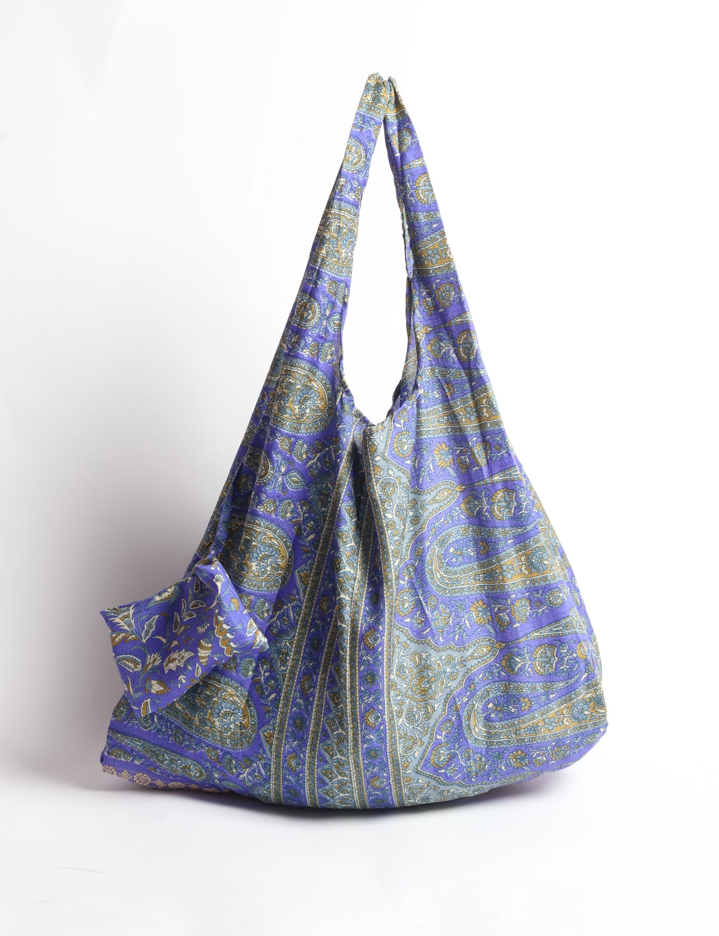 Stay eco-conscious with our Reusable Bag, handmade by Indian artisans from pre-loved saris. Silky and lightweight, this foldaway bag is perfect for your on-the-go lifestyle. Each piece is a unique statement of ethical fashion, embracing sustainability and style.