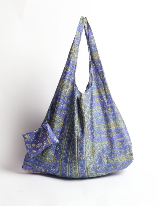 Stay eco-conscious with our Reusable Bag, handmade by Indian artisans from pre-loved saris. Silky and lightweight, this foldaway bag is perfect for your on-the-go lifestyle. Each piece is a unique statement of ethical fashion, embracing sustainability and style.