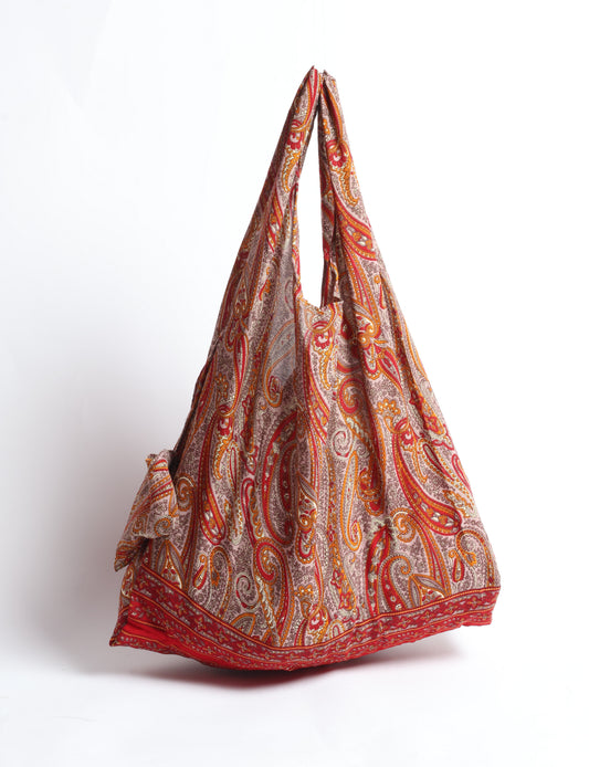 Stay eco-conscious with our Reusable Bag, handmade by Indian artisans from pre-loved saris. Silky and lightweight, this foldaway bag is perfect for your on-the-go lifestyle. Each piece is a unique statement of ethical fashion, embracing sustainability and style.