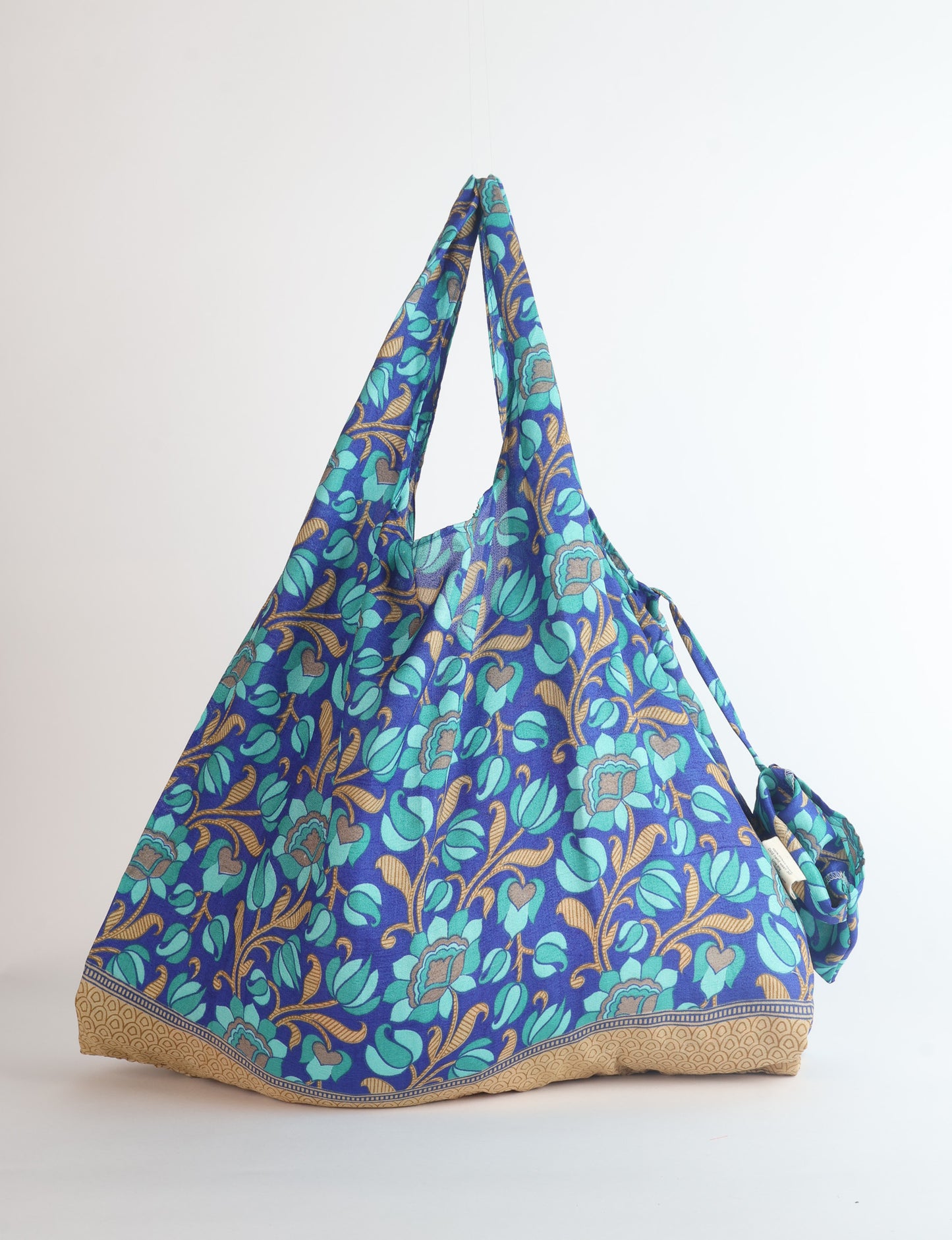Stay eco-conscious with our Reusable Bag, handmade by Indian artisans from pre-loved saris. Silky and lightweight, this foldaway bag is perfect for your on-the-go lifestyle. Each piece is a unique statement of ethical fashion, embracing sustainability and style.