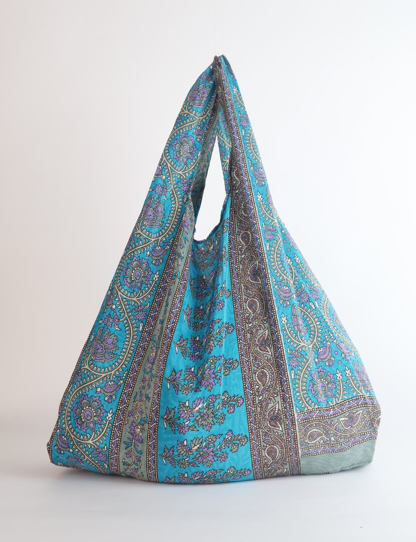Stay eco-conscious with our Reusable Bag, handmade by Indian artisans from pre-loved saris. Silky and lightweight, this foldaway bag is perfect for your on-the-go lifestyle. Each piece is a unique statement of ethical fashion, embracing sustainability and style.