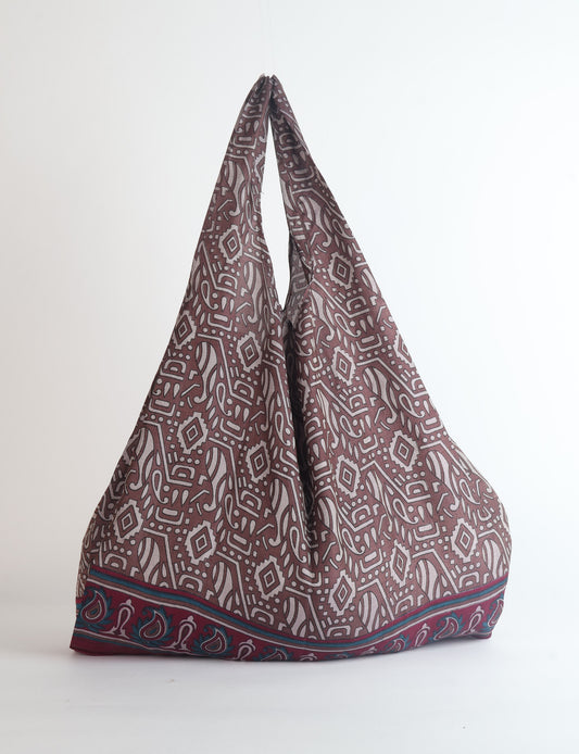Stay eco-conscious with our Reusable Bag, handmade by Indian artisans from pre-loved saris. Silky and lightweight, this foldaway bag is perfect for your on-the-go lifestyle. Each piece is a unique statement of ethical fashion, embracing sustainability and style.