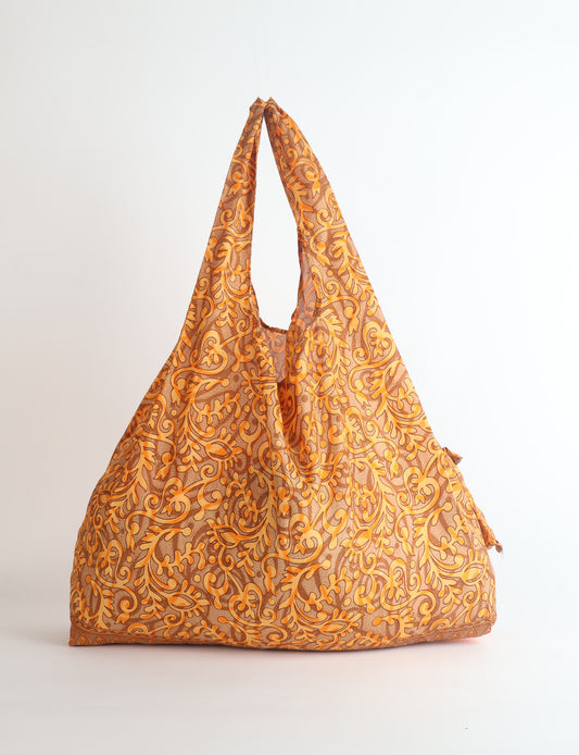 Stay eco-conscious with our Reusable Bag, handmade by Indian artisans from pre-loved saris. Silky and lightweight, this foldaway bag is perfect for your on-the-go lifestyle. Each piece is a unique statement of ethical fashion, embracing sustainability and style.