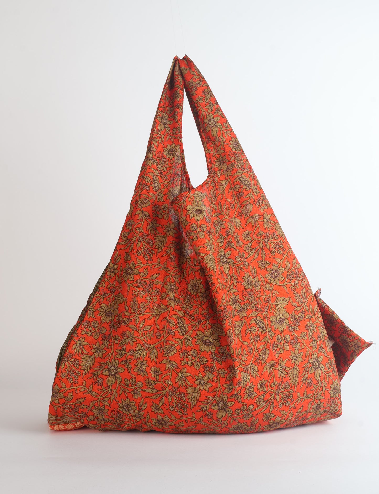 Stay eco-conscious with our Reusable Bag, handmade by Indian artisans from pre-loved saris. Silky and lightweight, this foldaway bag is perfect for your on-the-go lifestyle. Each piece is a unique statement of ethical fashion, embracing sustainability and style.