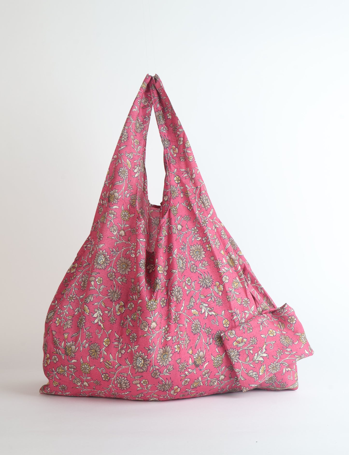 Stay eco-conscious with our Reusable Bag, handmade by Indian artisans from pre-loved saris. Silky and lightweight, this foldaway bag is perfect for your on-the-go lifestyle. Each piece is a unique statement of ethical fashion, embracing sustainability and style.
